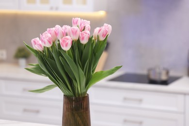 Photo of Beautiful bouquet of fresh pink tulips in kitchen. Space for text