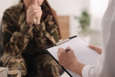 Photo of Psychotherapist working with military woman in office, closeup