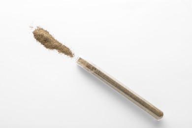 Photo of Glass tube with ground black pepper on white background, top view