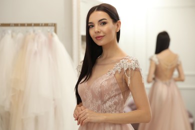 Photo of Woman trying on wedding dress in boutique