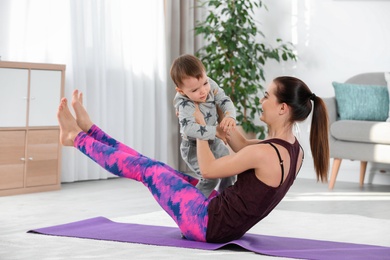 Woman doing fitness exercises together with son at home