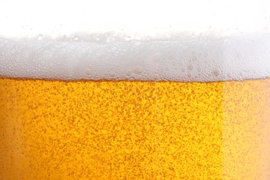 Photo of Tasty beer with foam in glass, closeup