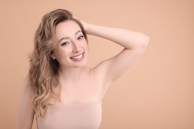 Portrait of smiling woman on beige background. Space for text