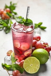 Photo of Soda water with grapes, ice, lime and mint on table. Refreshing drink