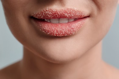 Photo of Closeup view of woman with lips covered in sugar on light grey background