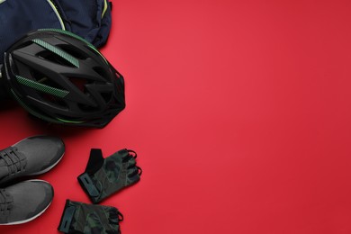 Photo of Flat lay composition with different cycling accessories on red background, space for text