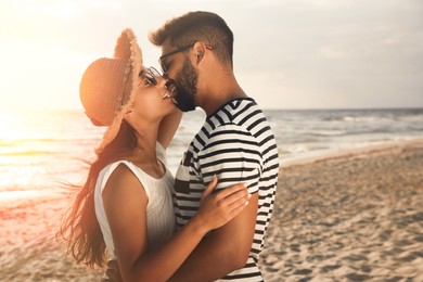 Photo of Lovely couple kissing on beach at sunset