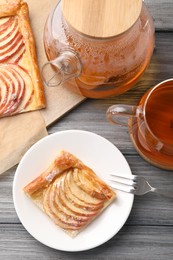 Tasty apple pie served with tea on grey wooden table, flat lay