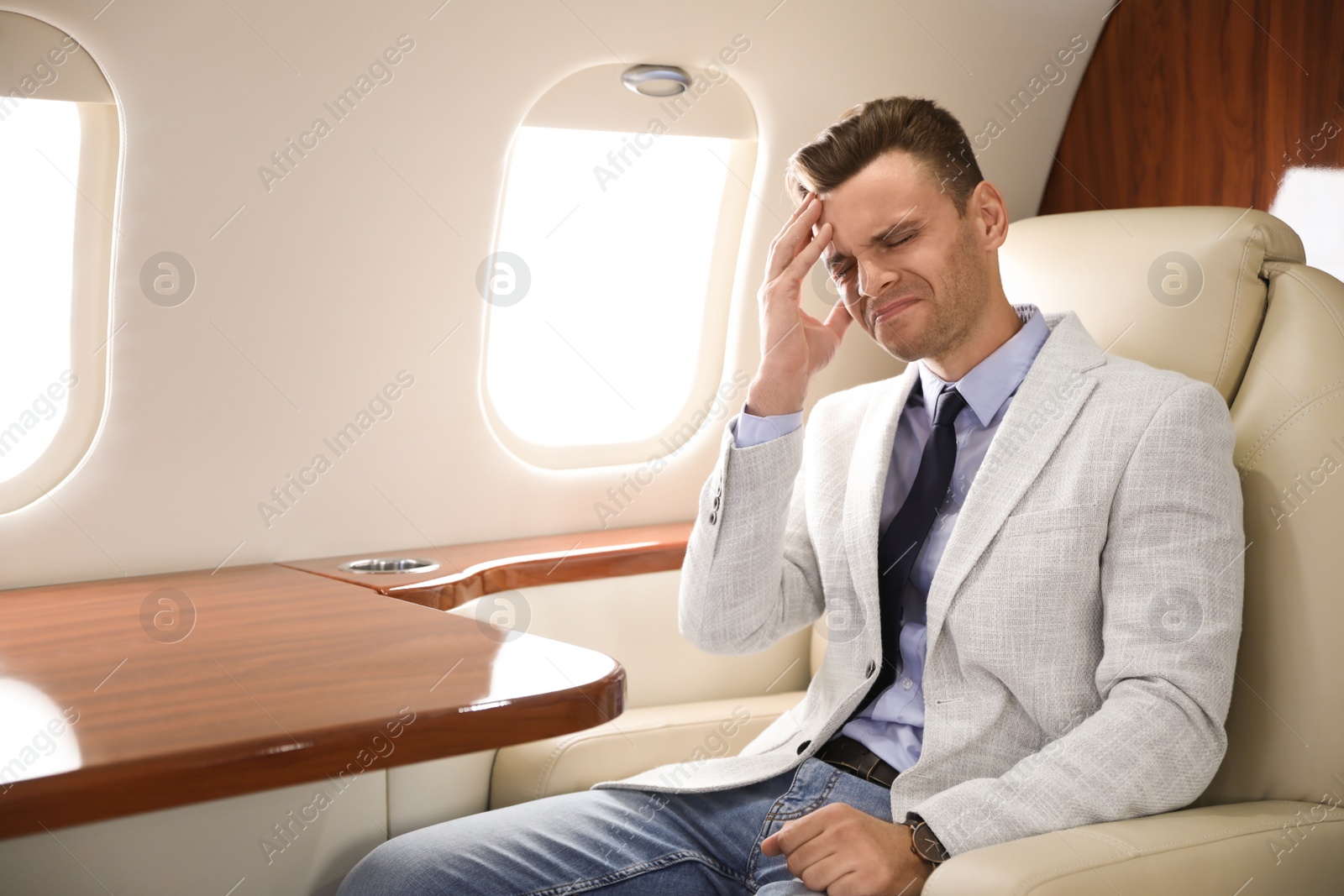 Photo of Young man suffering from headache during flight