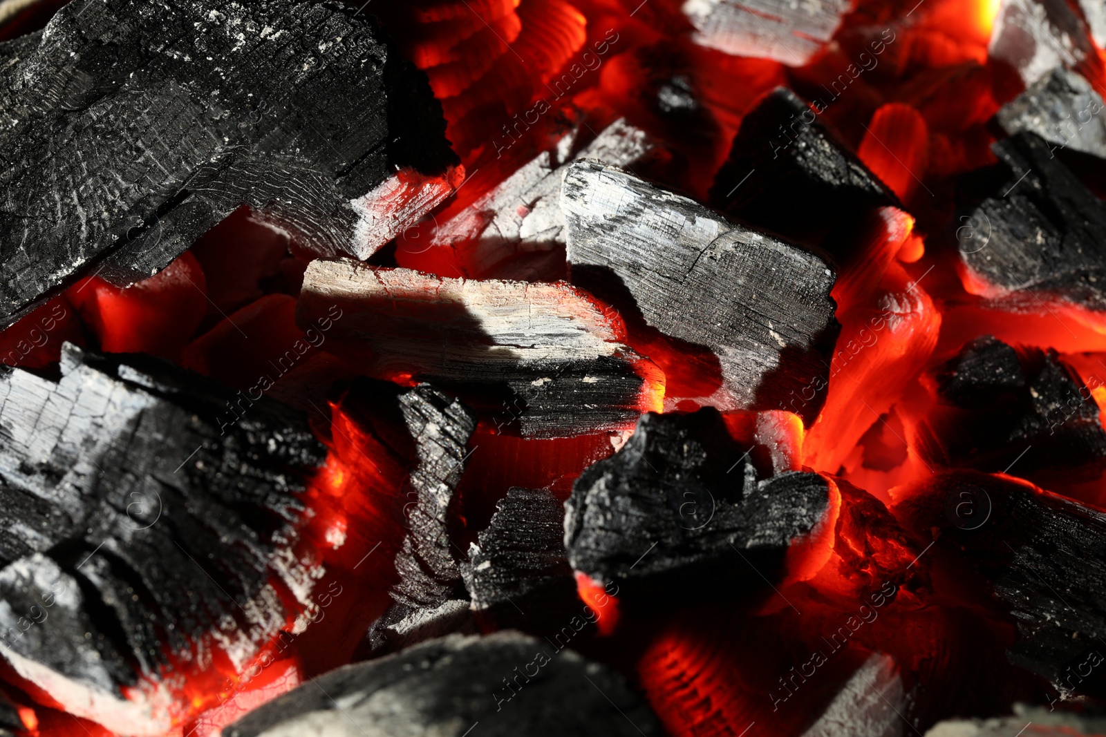 Photo of Pieces of hot smoldering coal as background, closeup