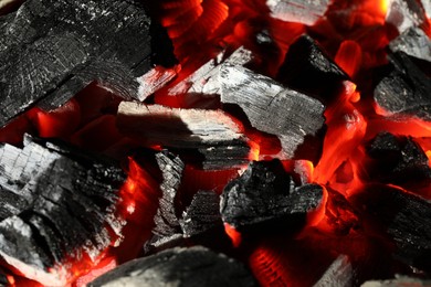 Photo of Pieces of hot smoldering coal as background, closeup