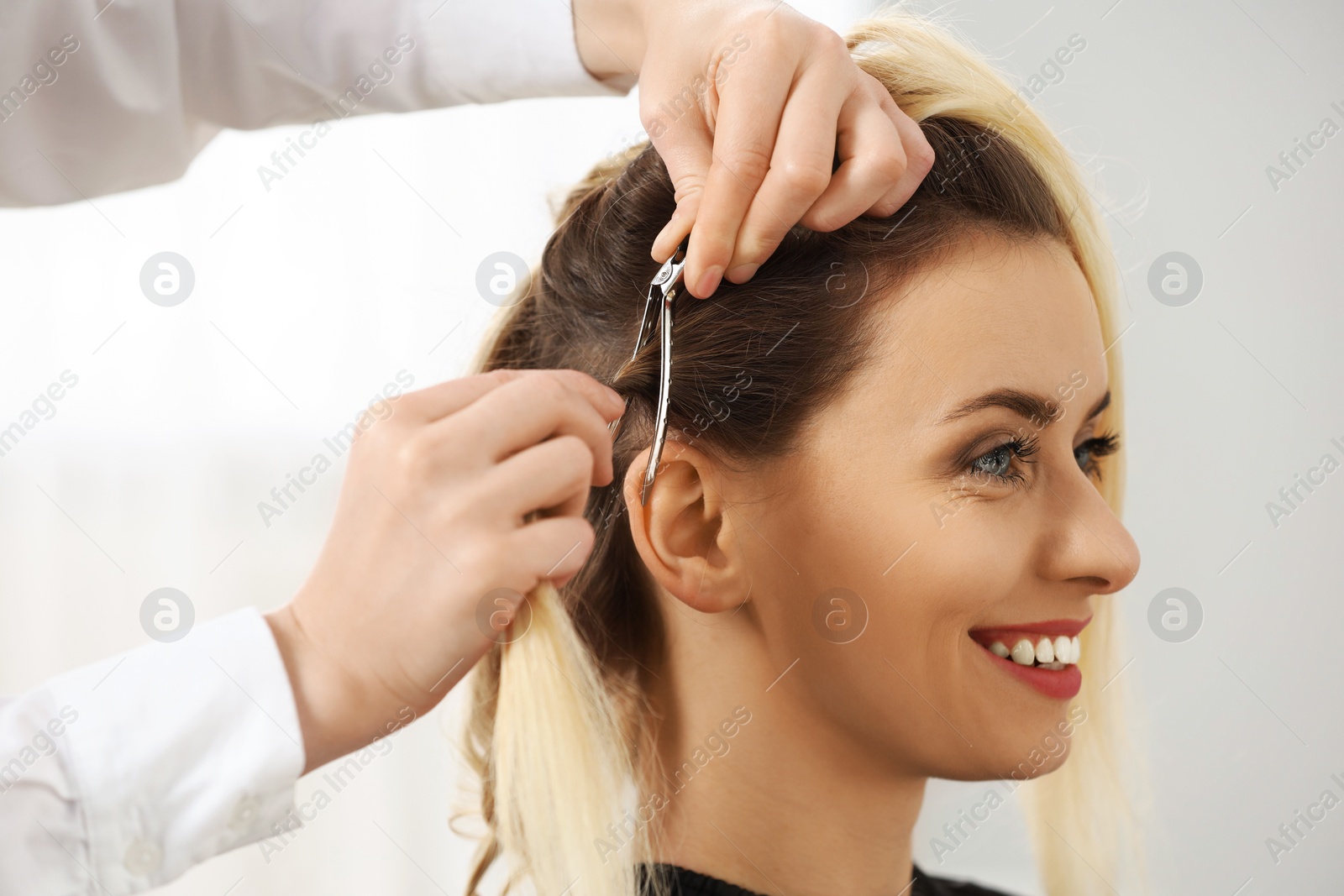 Photo of Hair styling. Professional hairdresser working with smiling client indoors, closeup