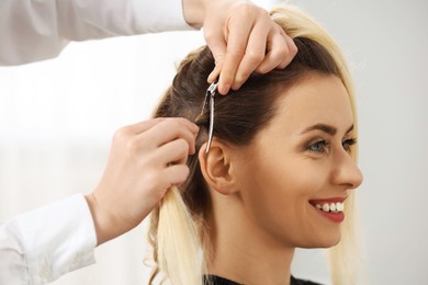 Photo of Hair styling. Professional hairdresser working with smiling client indoors, closeup