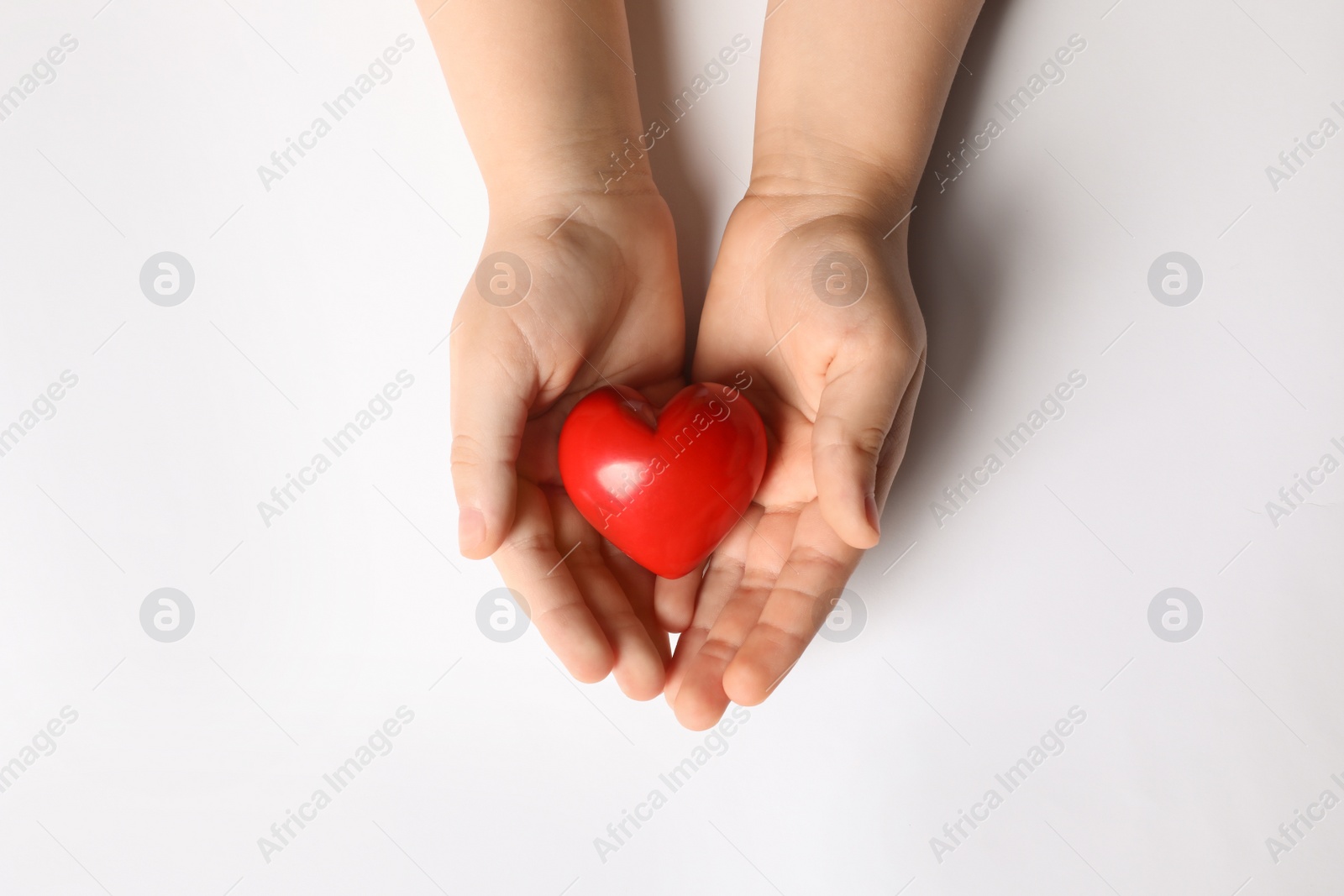 Photo of Woman holding red heart in hands on white background, top view