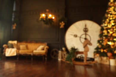 Photo of Blurred view of stylish room interior with Christmas tree, big vintage clock and festive decor