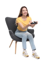 Happy woman with game controller sitting in armchair on white background