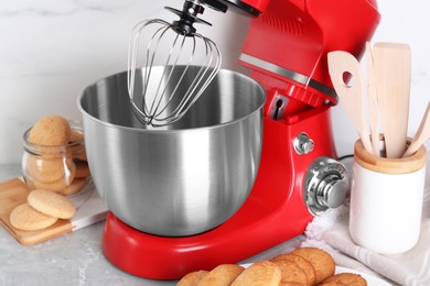 Photo of Modern red stand mixer and cookies on light gray marble table