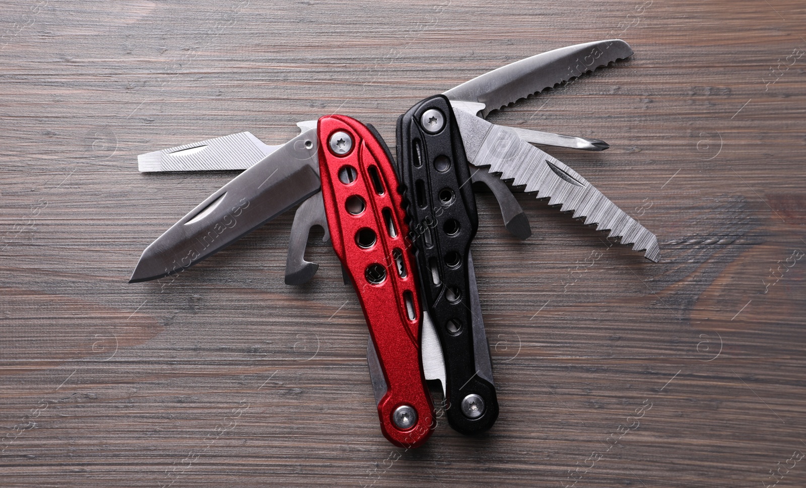 Photo of Modern compact portable multitool on wooden table, top view