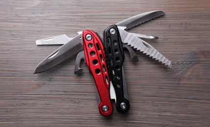 Modern compact portable multitool on wooden table, top view