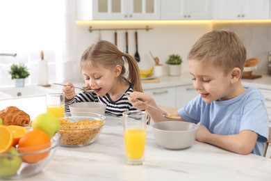 Little children having breakfast at table in kitchen, selective focus