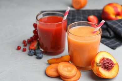 Delicious juices and fresh ingredients on grey table. Space for text