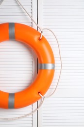 Photo of Orange lifebuoy on white wooden background. Rescue equipment