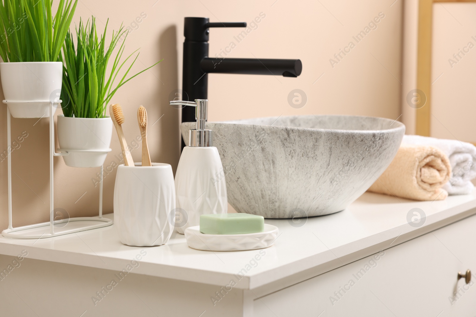 Photo of Different bath accessories and personal care products near sink on bathroom vanity