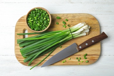 Photo of Composition with fresh green onions on white wooden background, top view