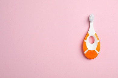 Manual toothbrush for child on color background, top view with space for text