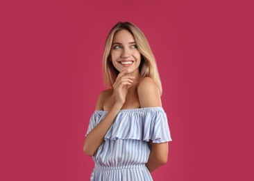 Photo of Young woman wearing stylish dress on pink background