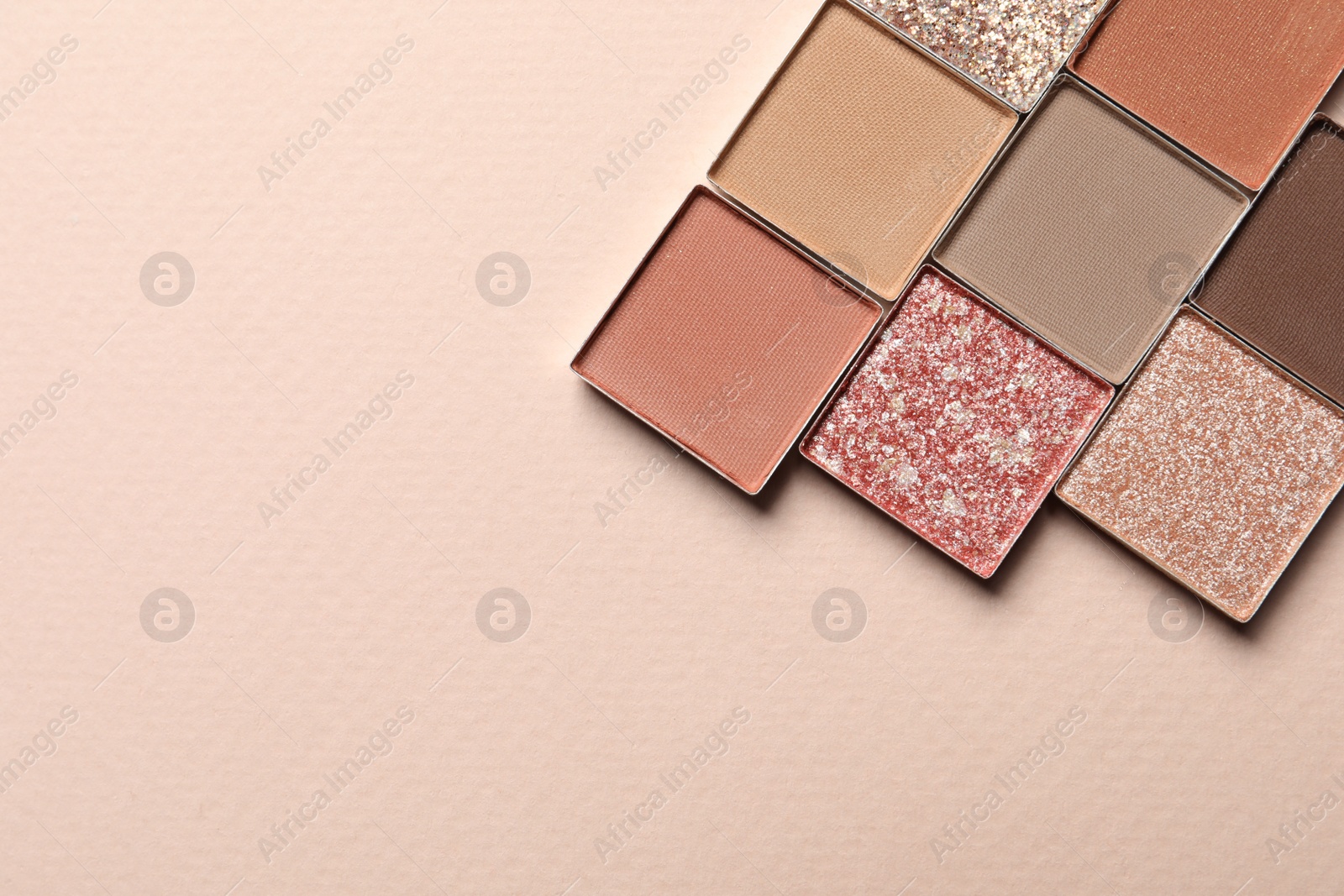 Photo of Different beautiful eye shadows on beige background, flat lay. Space for text
