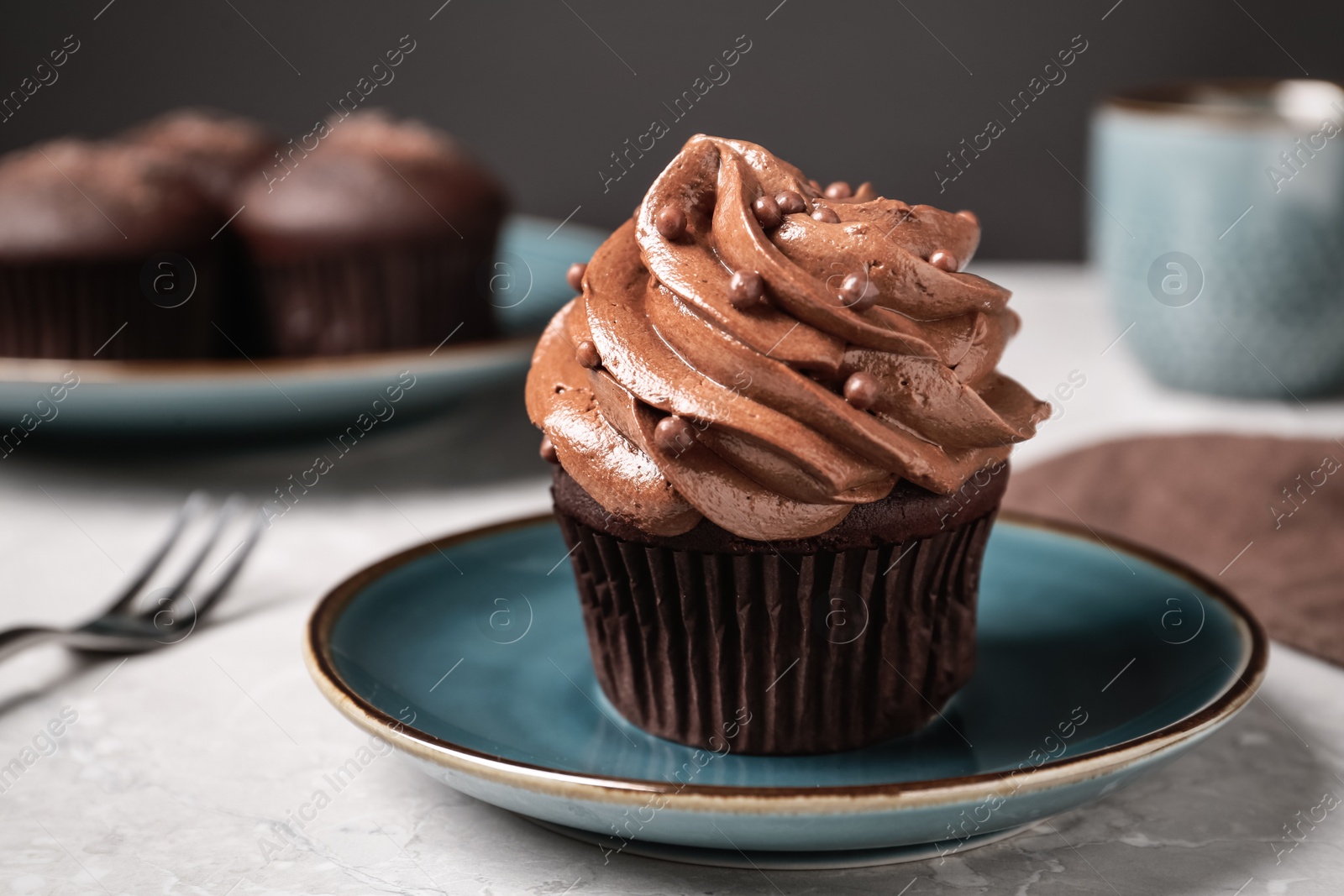 Photo of Delicious cupcake decorated with cream served on white table