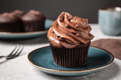 Photo of Delicious cupcake decorated with cream served on white table