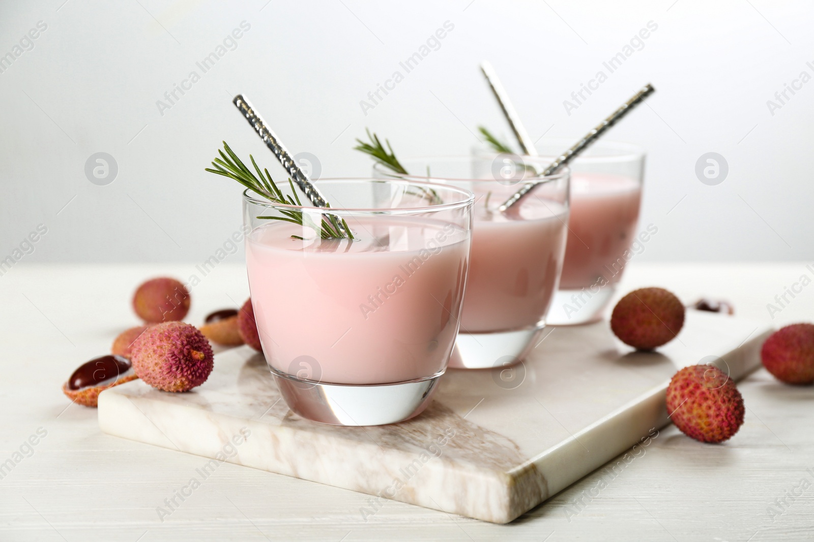 Photo of Lychee cocktail with rosemary on white table