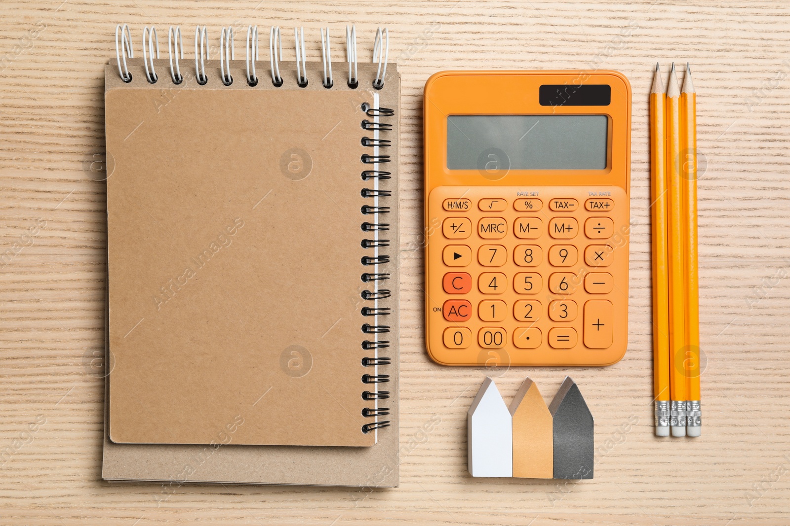 Photo of Calculator, notebook, stickers and pencils on wooden table, top view. Tax accounting