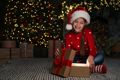 Happy child with magic Christmas gift on floor at home