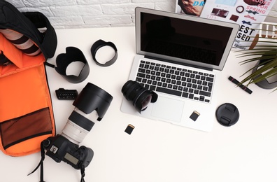 Photo of Laptop and professional photographer's equipment on table, top view. Space for text