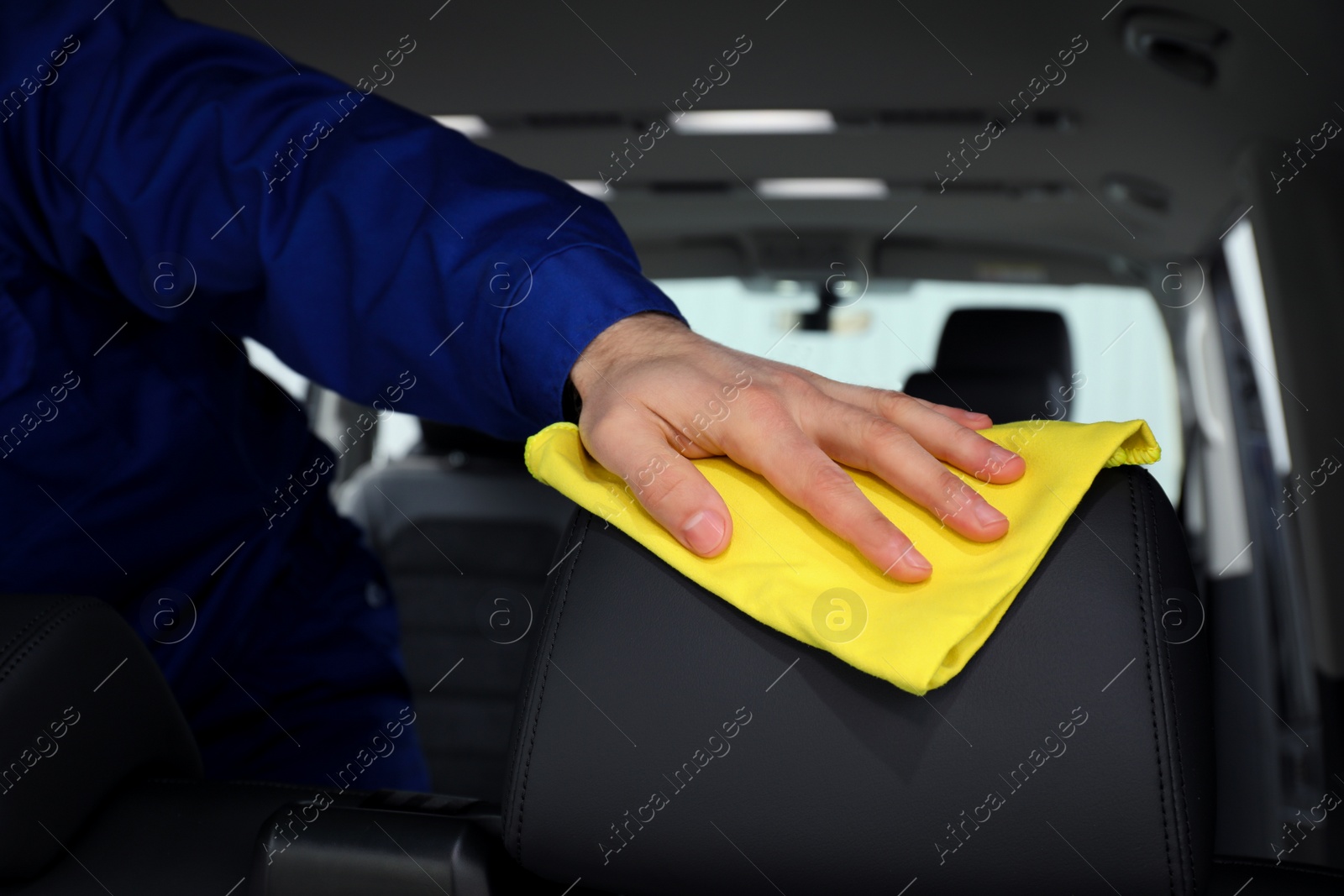 Photo of Car wash worker cleaning automobile interior, closeup