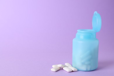 Photo of Jar with chewing gums on lilac background. Space for text