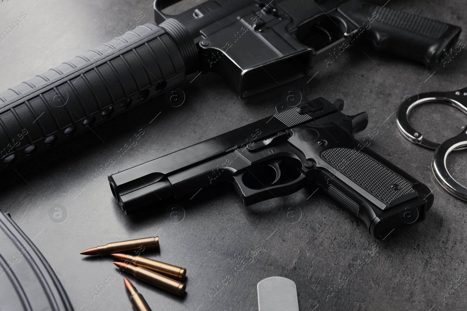 Photo of Composition with gun and bullets on stone table