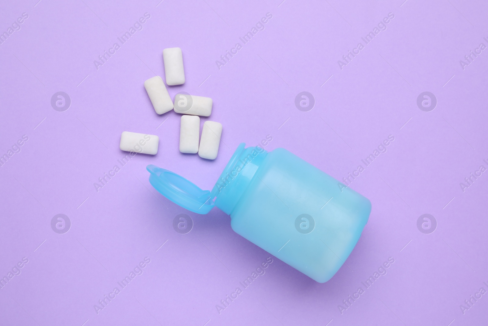 Photo of Jar with chewing gums on lilac background, flat lay