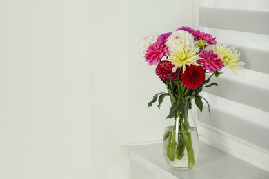 Photo of Bouquet of beautiful Dahlia flowers in vase on windowsill indoors. Space for text