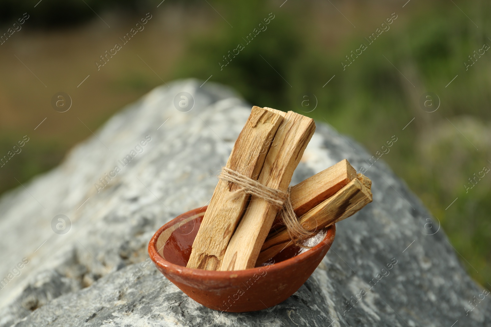 Photo of Many palo santo sticks on stone surface outdoors