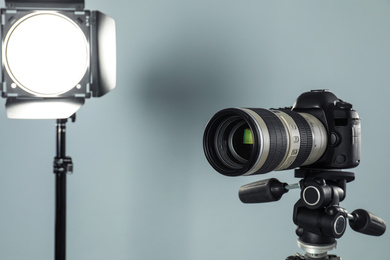 Professional video camera and lighting equipment on grey background