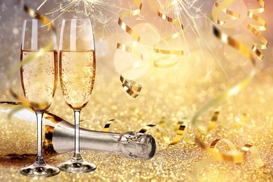 Glasses and bottle of sparkling wine on bright festive background 
