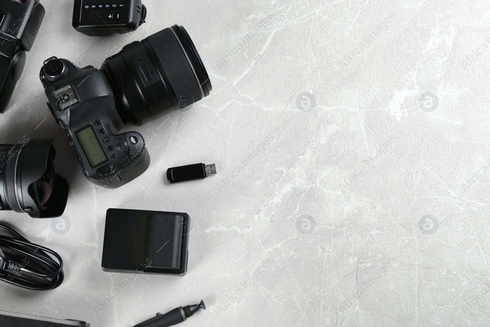 Photo of Flat lay composition with equipment for professional photographer on grey marble table. Space for text