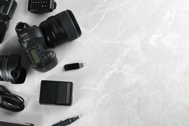 Flat lay composition with equipment for professional photographer on grey marble table. Space for text