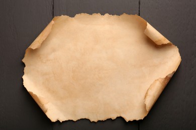 Sheet of old parchment paper on grey wooden table, top view