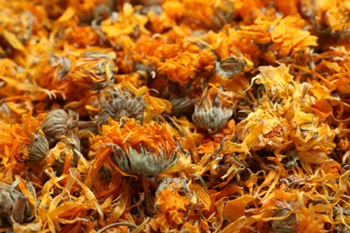 Photo of Pile of dry calendula flowers as background, closeup