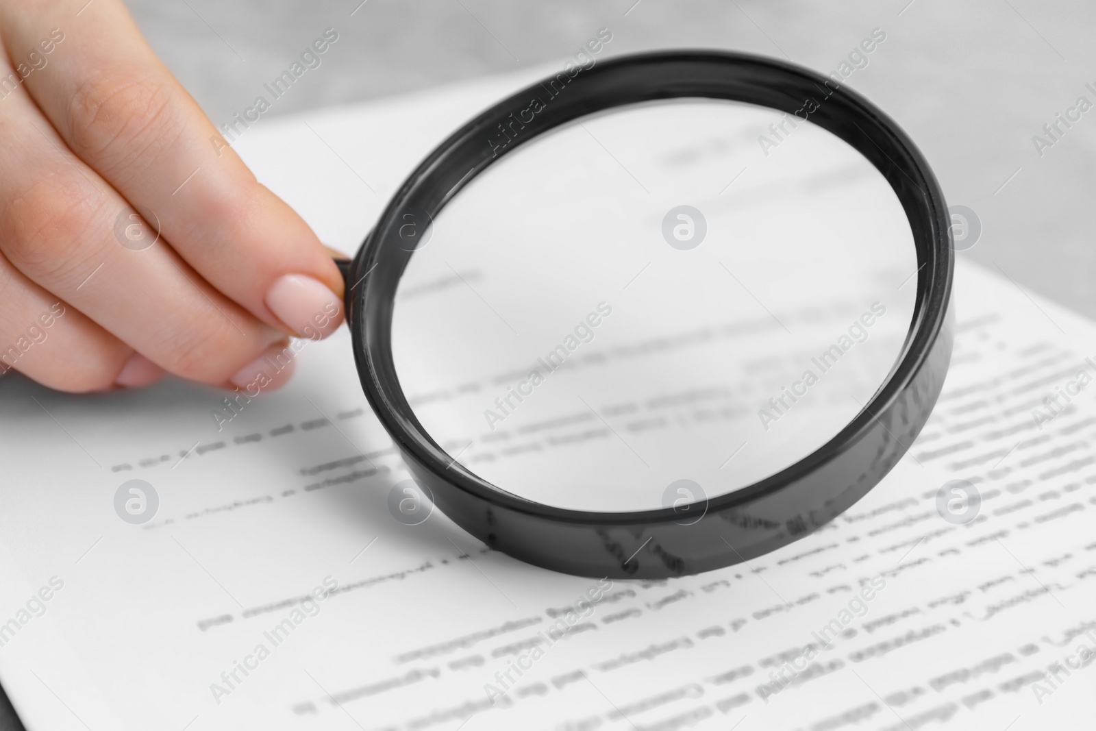 Photo of Woman looking at document through magnifier, closeup. Searching concept